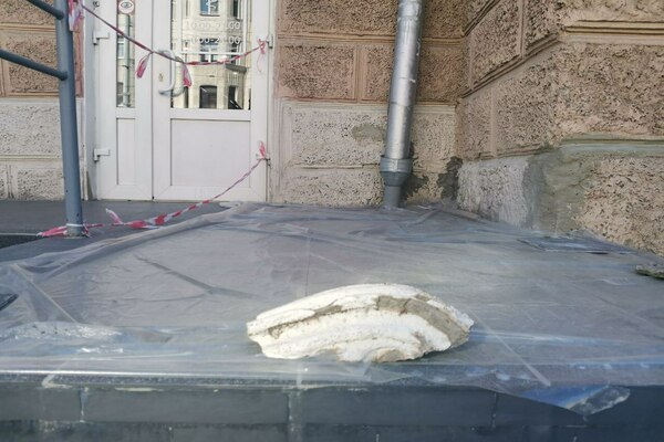 Фотафакт. У Магілёве ад дому адваліўся кавалак тынку і ім прыціснулі цырату, каб не знесла ветрам